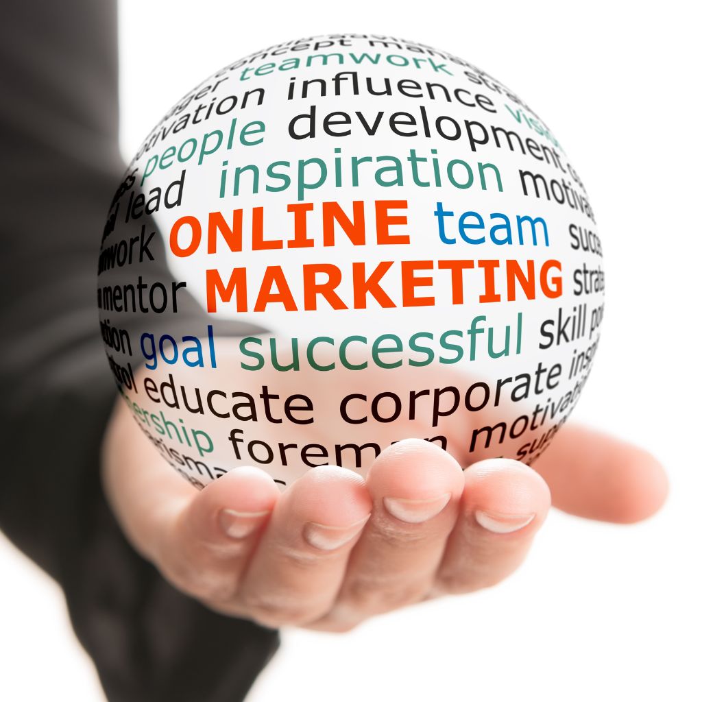 A hand holding a transparent glass orb, which contains a word cloud with words like "ONLINE MARKETING," "team," and "inspiration" highlighted in red.