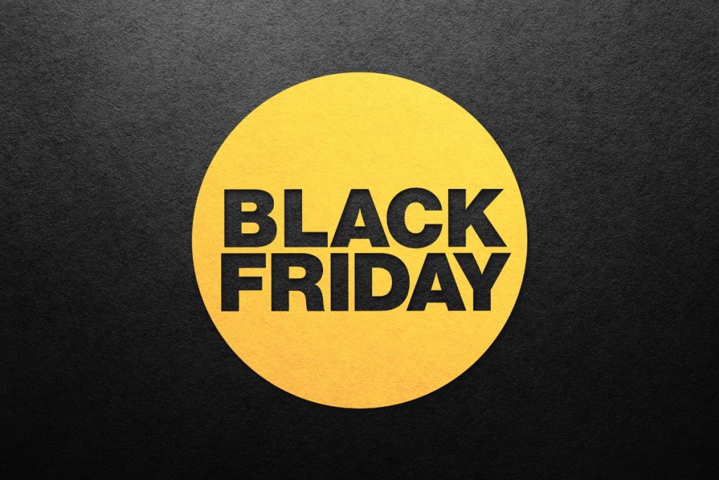 The words "BLACK FRIDAY" in bold black text inside a large yellow circle, centred on a dark, textured charcoal background.