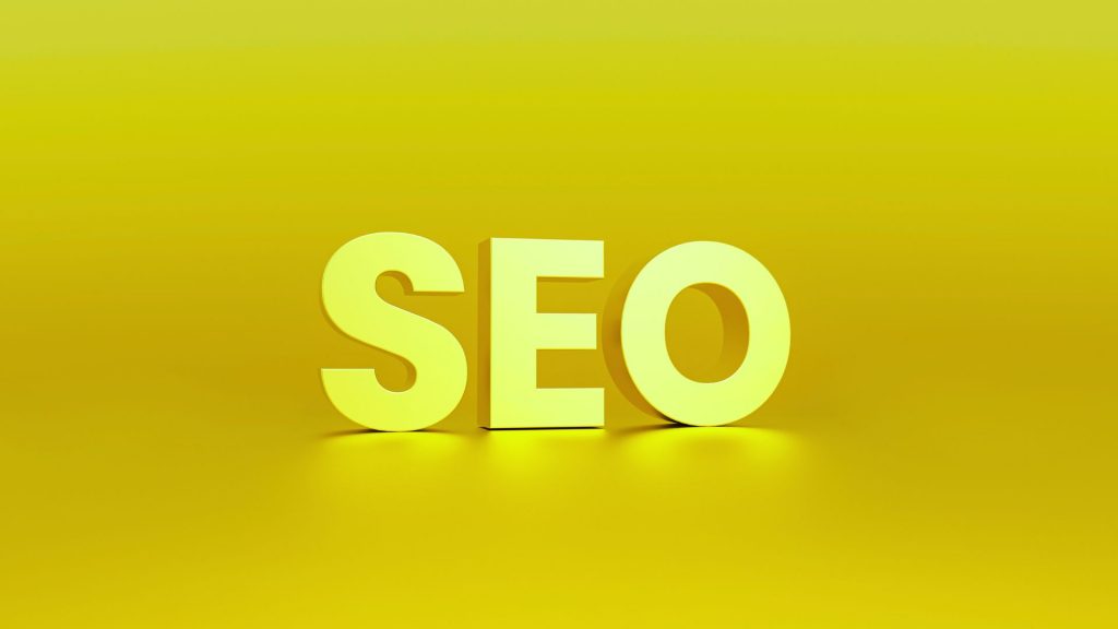 Large, 3D, pale yellow letters spelling "SEO" (Search Engine Optimisation) on a bright yellow background.