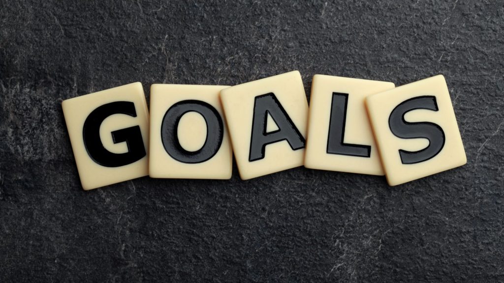 Scrabble-like tiles spelling out the word 'GOALS' on a dark background.