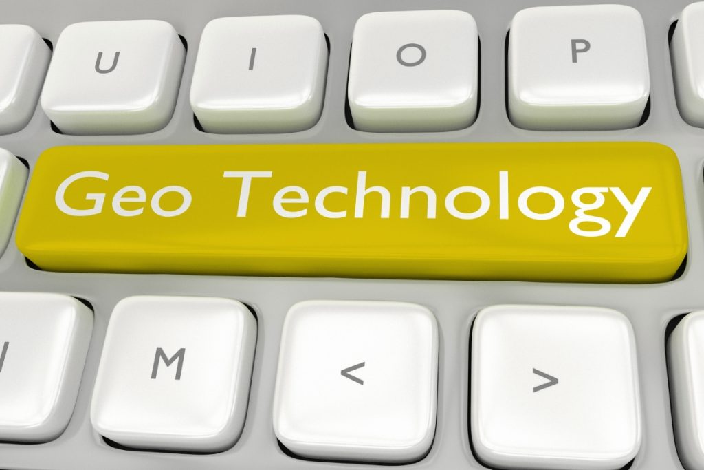 A close-up of a white computer keyboard with a single, elongated yellow key labeled "Geo Technology" in white text.