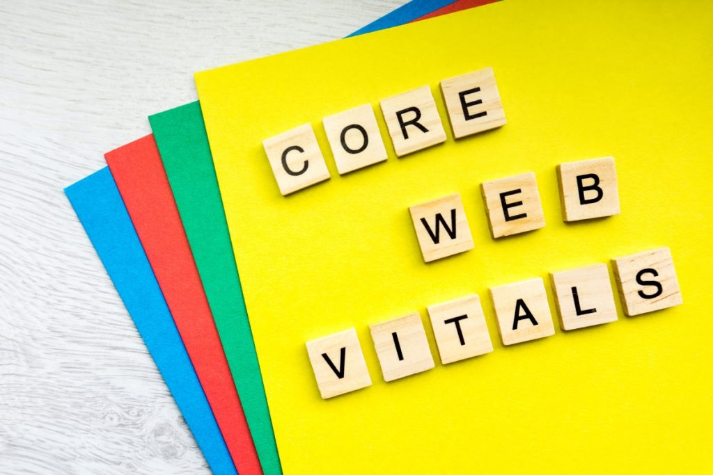Wooden tiles spelling out "CORE WEB VITALS" on a yellow background with colourful paper edges.