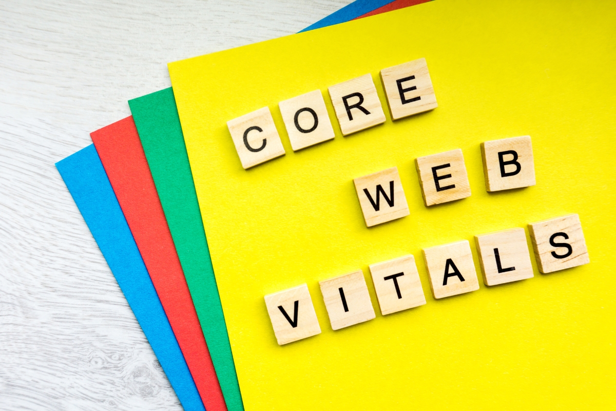 Wooden tiles spelling out "CORE WEB VITALS" on a yellow background with colourful paper edges.