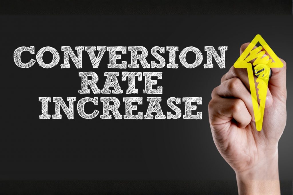 A hand drawing a yellow upward arrow next to the text "CONVERSION RATE INCREASE" on a dark background.