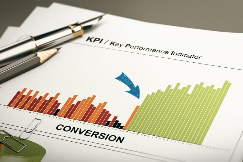 A person using a stylus on a digital tablet to analyse colourful bar charts and data graphs.