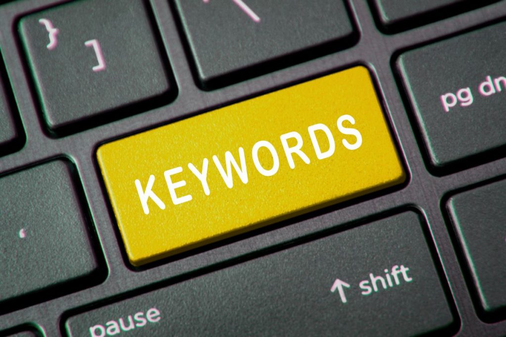 A digital graphic showing a target with an arrow in the center, surrounded by "Target Keywords" text and floating search tag icons.