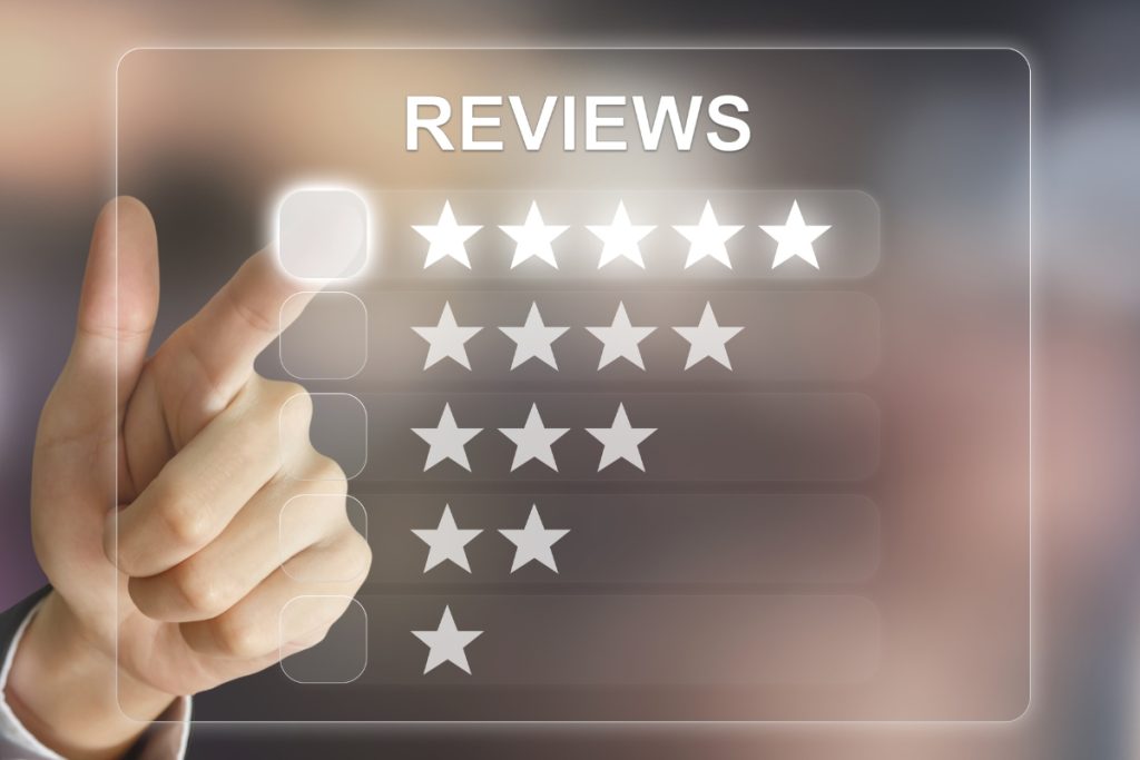 A person’s hand pointing to a digital five-star rating overlay interface, with options ranging from one to five stars under the heading "REVIEWS".