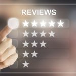A person’s hand pointing to a digital five-star rating overlay interface, with options ranging from one to five stars under the heading "REVIEWS".